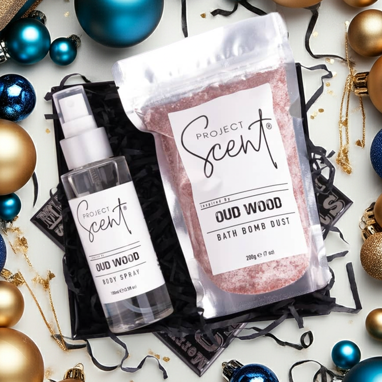 Project Scent Oud Wood bath bomb dust and spray surrounded by festive ornaments on a white background