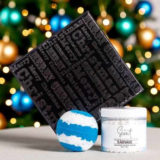 Decorative items including a black textured box, blue and white bath bomb, and a whipped sugar scrub  against a festive background.