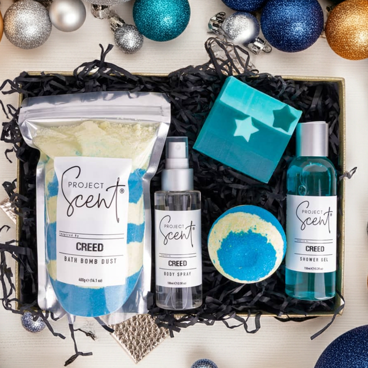 Gift set with Project Scents products surrounded by festive ornaments on a white background