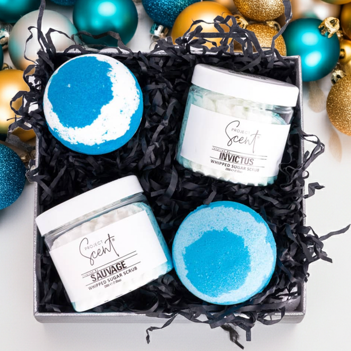 Gift set with bath bombs and Whipped Sugar Scrub surrounded by festive ornaments on a white background