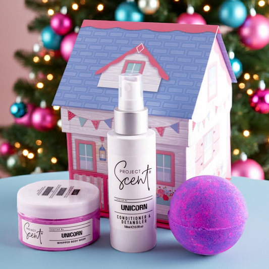 Cosmetic set with 'Project Scents' branding in front of a decorated Christmas tree.