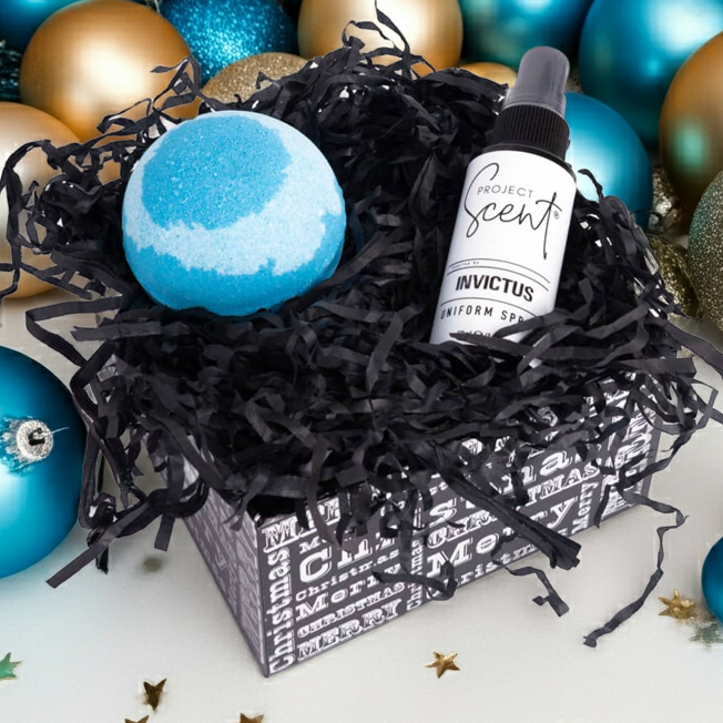 Decorative box with blue and gold ornaments and a bottle of Project Scents Uniform Spray and  bath bomb.