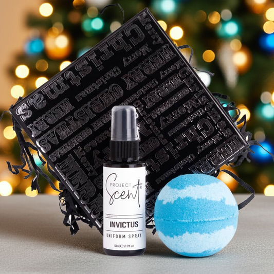 Project Scent Invictus uniform spray bottle and bath bomb with black packaging against a festive background.