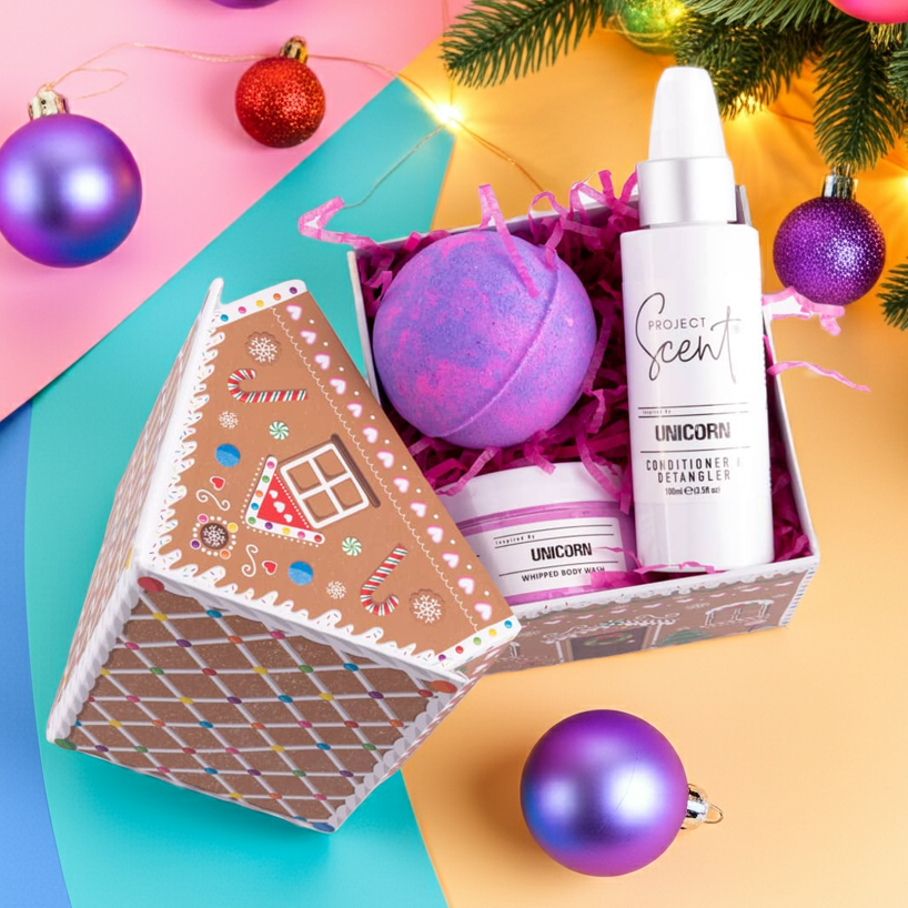Gingerbread house-shaped gift box with bath bomb and bottles on a colorful background with Christmas decorations.