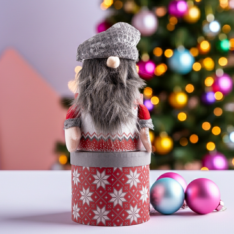 Gnome figurine in a red and white patterned outfit with a Christmas tree in the background.