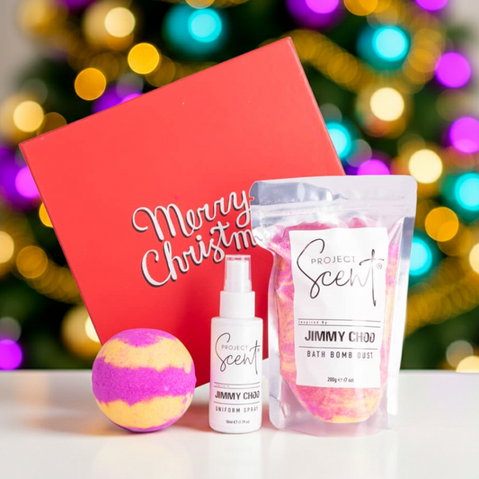 Christmas bath and fragrance gift set displayed in front of a Christmas tree. Includes handmade bath dust, bath bomb and uniform spray in festive packaging.