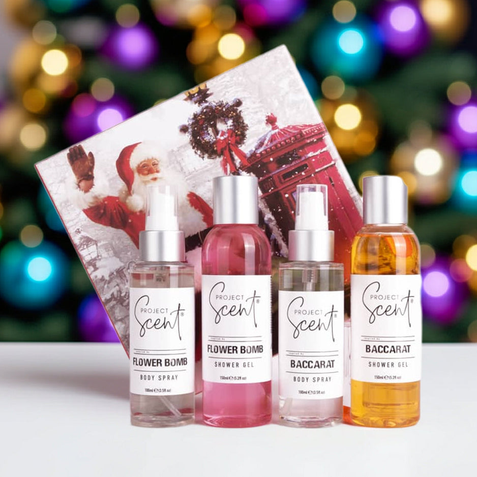 Christmas body care gift set displayed in front of a Christmas tree. Includes two handmade shower gels and two body sprays in festive gift packaging.
