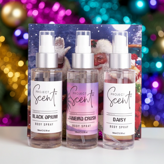 Christmas body spray gift set displayed in front of a Christmas tree. Includes three handmade Eau de Toilette strength body sprays in festive packaging.