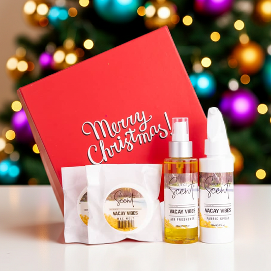 Christmas home fragrance gift set in front of a Christmas tree. Includes handmade fabric spray, air freshener and wax melts in festive packaging.