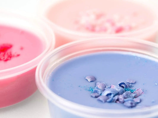 Close up of Wax Melts in pink, cerise and purple with a decorative top