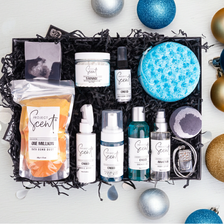Collection of beauty products in a decorative box with Christmas ornaments on a white background