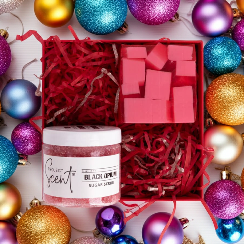 Flatlay of Christmas body care gift set surrounded by festive decorations. Features handmade whipped sugar scrub and soap bar, beautifully boxed.