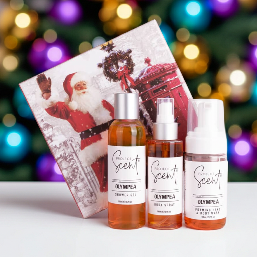 Christmas body care gift set displayed in front of a Christmas tree. Includes handmade shower gel, foaming body wash and body spray in festive packaging.