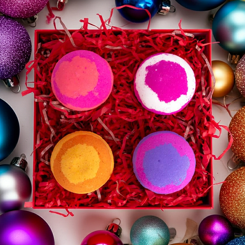 Flatlay of Christmas bath bomb gift set surrounded by festive decorations. Features four handmade bath bombs in colourful Christmas packaging.