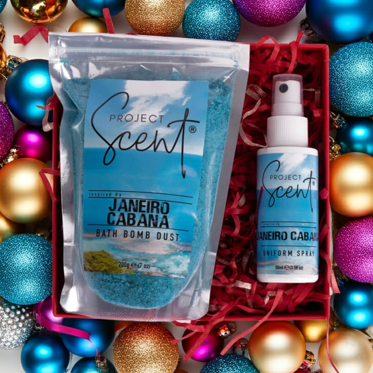 Flatlay of Christmas bath and fragrance gift set surrounded by festive decorations. Features handmade bath dust and uniform spray gift box.