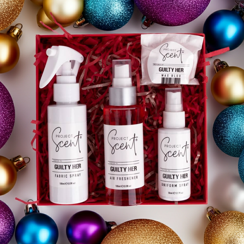 Flatlay of Christmas home fragrance gift set surrounded by festive decorations. Features handmade air freshener, fabric spray, uniform spray and wax blox.