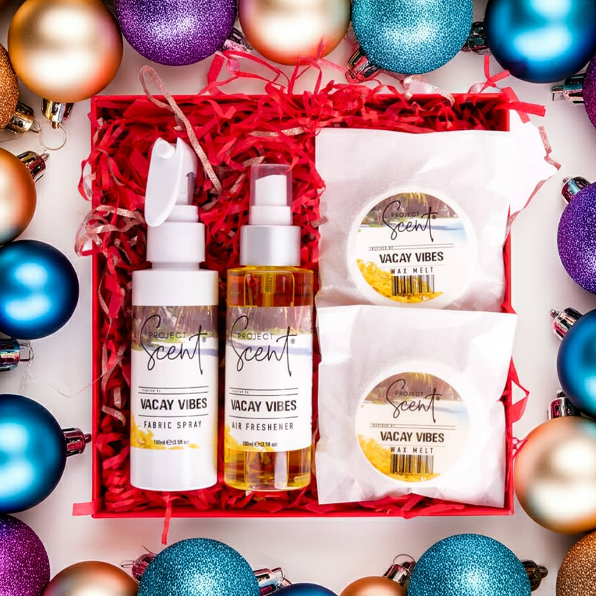 Flatlay of Christmas home fragrance gift set surrounded by festive decorations. Features handmade fabric spray, air freshener and wax melts gift box.