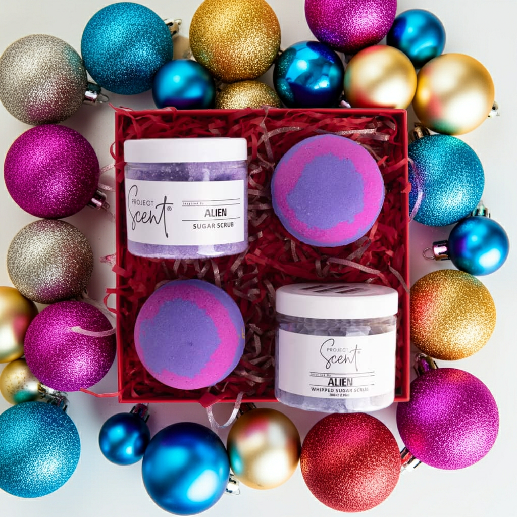 Flatlay of Christmas pamper gift set surrounded by festive decorations. Features handmade whipped sugar scrub, sugar scrub and two bath bombs.