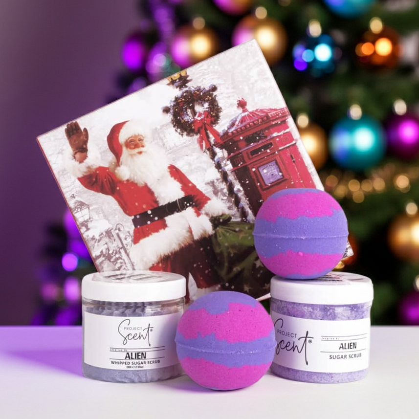 Christmas pamper gift set displayed in front of a Christmas tree. Includes handmade whipped sugar scrub, sugar scrub and two festive bath bombs.